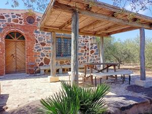 um pátio com uma mesa de piquenique e um edifício de pedra em Sardegna Antico casale Cod. IUN Q4789 em Orosei