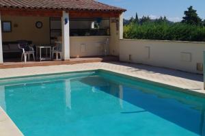 a swimming pool with blue water in front of a house at le clos des sources in Saint-Chamas