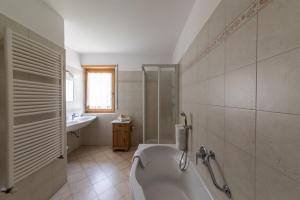 uma casa de banho branca com uma banheira e um lavatório em Haus Adlerhorst em Ultimo