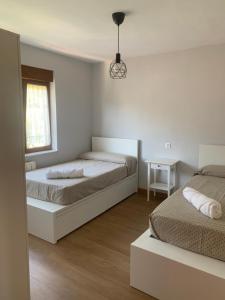 a bedroom with two beds and a window at EL RINCON DE PARRES in Parres de Llanes