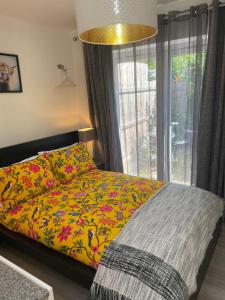 a bedroom with a bed with a colorful comforter and a window at A Room at The Oaks in Golden Valley