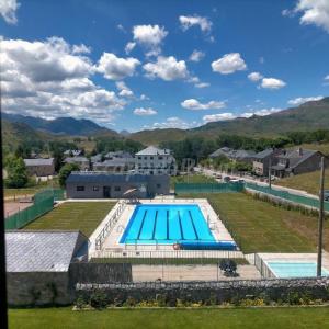 a large swimming pool in a field next to a house at Bajo los nidos 2 in San Emiliano