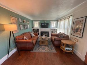 sala de estar con muebles de cuero y chimenea en Quaint house in the heart of Idaho Falls, en Idaho Falls