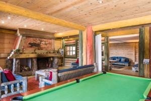 a pool table in a room with a fireplace at Résidence Pierre & Vacances Premium Le Roselend in Arc 1800