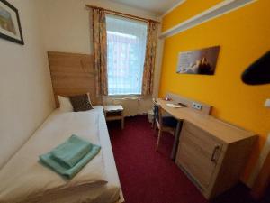 ein Hotelzimmer mit einem Bett, einem Schreibtisch und einem Fenster in der Unterkunft Landguthotel Hotel-Pension Sperlingshof in Dallgow