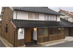 a building with a sign in front of it at MACHIYA HOTEL madoka - Vacation STAY 65847v in Izumo