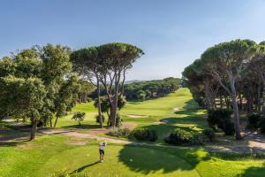 Ein Mann steht auf einem Golfplatz in der Unterkunft Golf Hôtel de Valescure & Spa NUXE in Saint-Raphaël