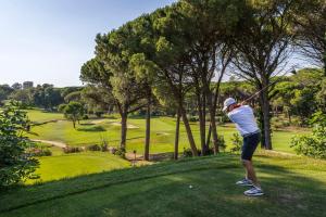 a man swinging a golf club on a golf course at Golf Hôtel de Valescure & Spa NUXE in Saint-Raphaël