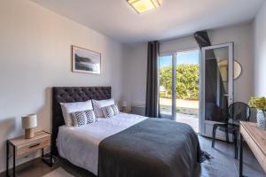 a bedroom with a bed and a sliding glass door at Villa Acula in Monticello +11 photos