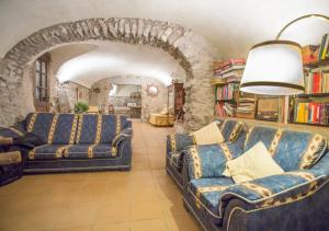 una sala de estar con 2 sofás y una pared de piedra. en Turismo Rural Can Massot en Darnius