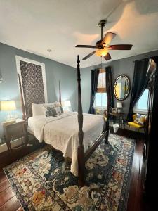 1 dormitorio con 1 cama con ventilador de techo y alfombra en Barksdale House Inn en Charleston