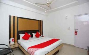 a bedroom with a large bed with red pillows at Hotel Gwal Palace By WB Inn in Agra