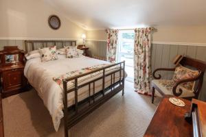 a bedroom with a bed and a chair and a window at The Georgian - Norfolk Cottage Agency in East Dereham