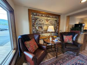 a living room with two chairs and a table and a rug at The Inn at Shady Lawn in Newland