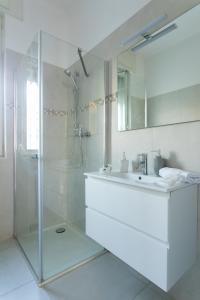 ein weißes Bad mit einem Waschbecken und einer Dusche in der Unterkunft Cozy Flat Romeo Menti - Vicenza in Vicenza