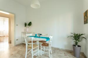 ein Esszimmer mit einem weißen Tisch und Stühlen in der Unterkunft Cozy Flat Romeo Menti - Vicenza in Vicenza