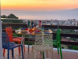 - une table avec des chaises et des oiseaux assis sur le balcon dans l'établissement CASA ACAMPORA, à Sorrente