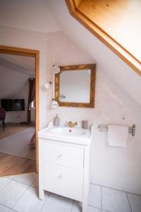 a bathroom with a white sink and a mirror at ApartOne Land-Hotel in Sebnitz