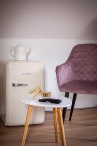 una mesa y una silla junto a una nevera en ApartOne Land-Hotel, en Sebnitz