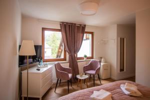 a bedroom with a bed and two chairs and a window at ApartOne Land-Hotel in Sebnitz