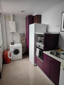 cocina con nevera blanca y lavadora en Precioso piso en Puerto Real, perfecta ubicación., en Puerto Real