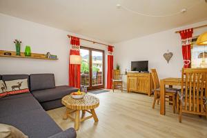 a living room with a couch and a table at Ferienwohnung Schmankerl in Reit im Winkl