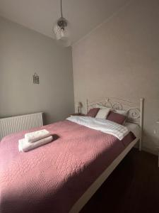 - une chambre dotée d'un grand lit avec des draps et des oreillers roses dans l'établissement Old Town Apartment, à Cracovie