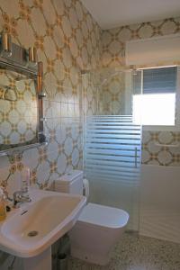 ein Badezimmer mit einem weißen WC und einem Waschbecken in der Unterkunft Ca La Rosita in Sant Jaume de Llierca