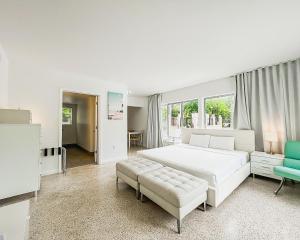 - une chambre blanche avec un grand lit blanc et un canapé dans l'établissement Tranquilo, à Fort Lauderdale
