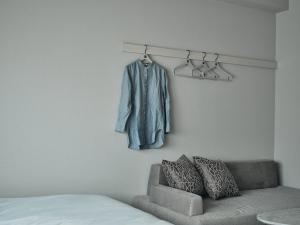 a room with a couch and a coat hanging on a wall at FAV HOTEL HIROSHIMA STADIUM in Hiroshima