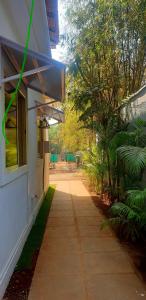 a sidewalk next to a building with a window and trees at Casa Aluizio in Assagao