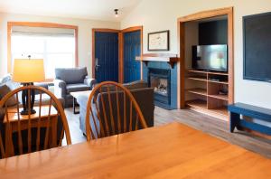 een woonkamer met een bank, een tafel en een televisie bij Rodd Brudenell River Resort in Cardigan
