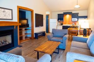 a living room with blue furniture and a fireplace at Rodd Brudenell River Resort in Cardigan