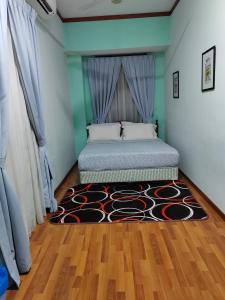 a bedroom with a bed with a rug on the floor at 1511 Guest House in Melaka