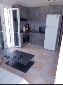 a kitchen with a table and a white refrigerator at Α Peaceful Nest in Volimes