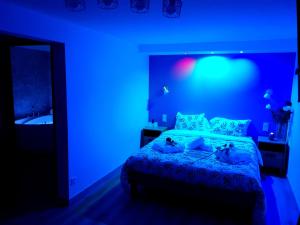 a blue bedroom with a bed with blue lights at Logis Hotel- Restaurant La Haie Des Vignes Séminaires et Evènementiel in Allain