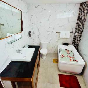 a bathroom with a sink and a tub and a toilet at III Felix Villas in Naga