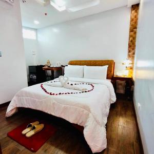 a bedroom with a bed with two shoes on it at III Felix Villas in Naga