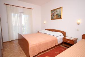 sypialnia z dwoma łóżkami i obrazem na ścianie w obiekcie Apartments by the sea Vlasici, Pag - 6523 w mieście Povljana