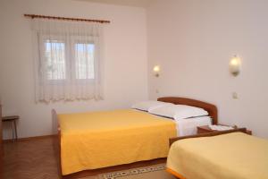 sypialnia z dwoma łóżkami i oknem w obiekcie Apartments by the sea Vlasici, Pag - 6523 w mieście Povljana