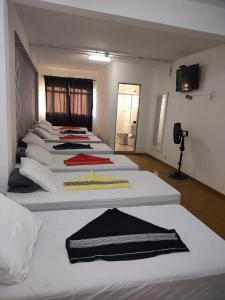 a row of beds lined up in a room at Hotel Nobre Requinte in Arujá