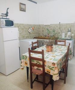 een keuken met een tafel en stoelen met een tafelkleed erop bij Gîte et jardin en bord de rivière in Saumane