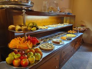 um buffet com muitos tipos diferentes de frutas e doces em Hotel Il Vecchio Mulino em Arbatax