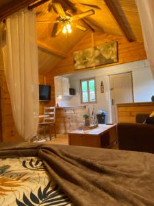a bedroom with a bed and a ceiling fan at Au chalet Fleuri in Ablon