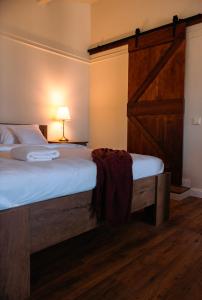 a bedroom with a large bed with a wooden door at Mediterana Studio next to Baile Felix in Sînmartin