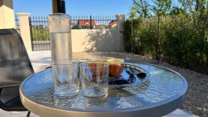een tafel met twee glazen en een fles water erop bij Mediterana Studio next to Baile Felix in Sînmartin