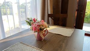 een vaas gevuld met bloemen zittend op een tafel bij Mediterana Studio next to Baile Felix in Sînmartin
