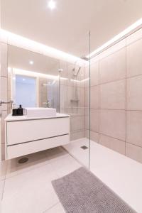 La salle de bains blanche est pourvue d'un lavabo et d'un miroir. dans l'établissement Lusíadas 53 2ºD - Beautiful two-bedroom apartment, à Lisbonne