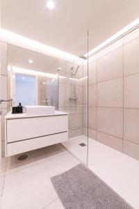 Un baño blanco con lavabo y espejo. en Lusíadas 53 2ºD - Beautiful two-bedroom apartment, en Lisboa