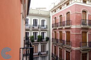 a row of buildings with balconies on a street at Citizentral Juristas in Valencia